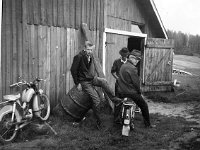 keskinen(5)  Erkki Oksala istuu bensatynnyrin päällä, Eero Hagren moottoripyörän selässä ja takana seisoo Erkin veli Pertti Oksala. Kauppavaraston seinää vasten on vuosimallin 1961 Tunturi