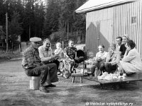 korpela(24)  Juhannusmakkaroiden grillausta Korpelan pihassa: Vasemmalta Timo Salonen (25.5.1911 - 3.8.1993), Aarne Salminen (13.5.1928 - 10.1.2009), Juha (polkupyörällä) Salonen ja Lempi Salonen (o.s. Kuparinen, 15.10.1914 - 24.1.2005), Ari Repo (leikkiautossa), Timo Salonen (poika), Kirsi Pajula, Elias Repo, Vieno Repo ja Airi Salonen