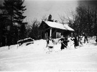 korpela(31)  Vekkulan koululaisia laskemassa suksilla mäkeä takanaan Rauhalan talo.